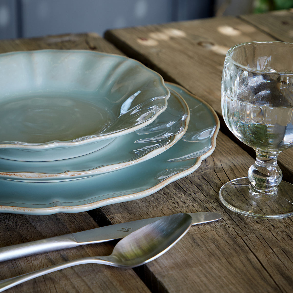 Stacked front-angle view of Alentejo Collection salad plates in turquoise showcasing scalloped rims and glossy glaze on a rustic wooden table