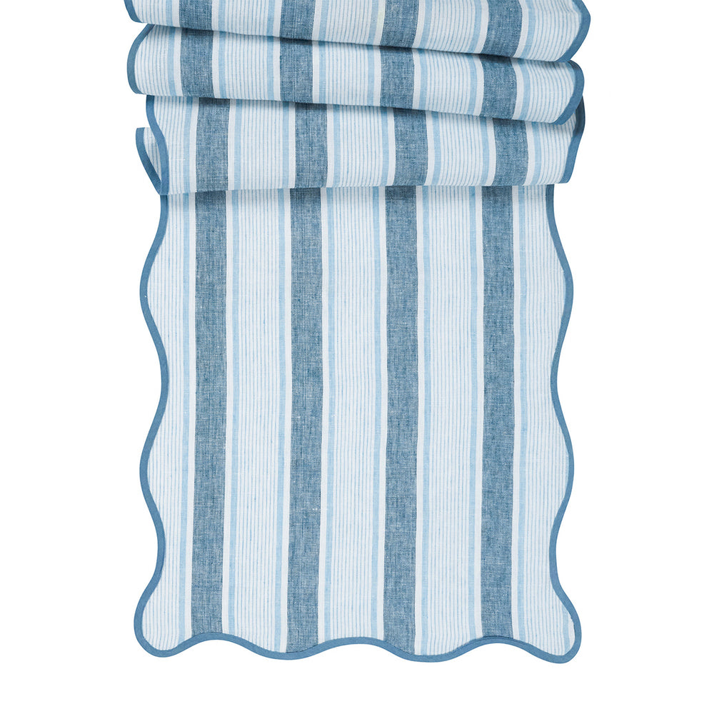 Front view of Cabana Stripe table runner in Ocean showcasing blue vertical stripes and scalloped trim on white background