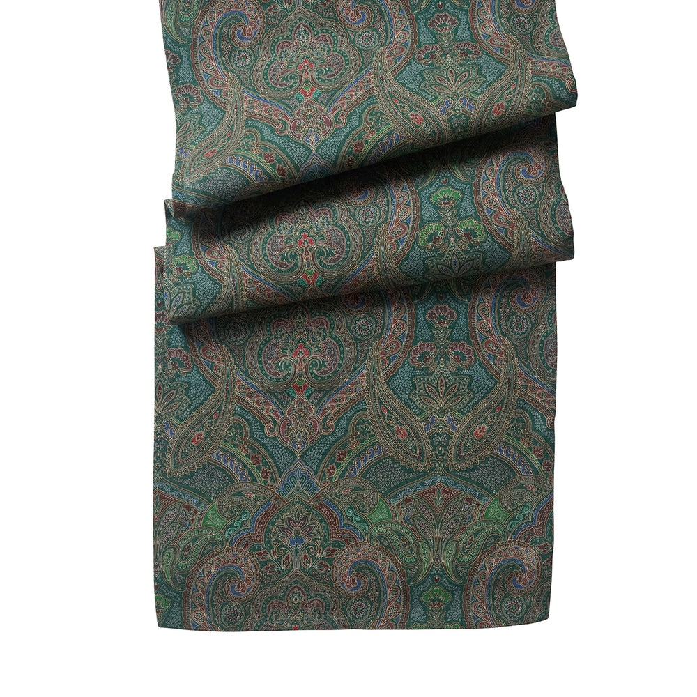 Folded view of Juliska Paisley 18 x 90 table runner in evergreen showcasing its intricate paisley print against a white background
