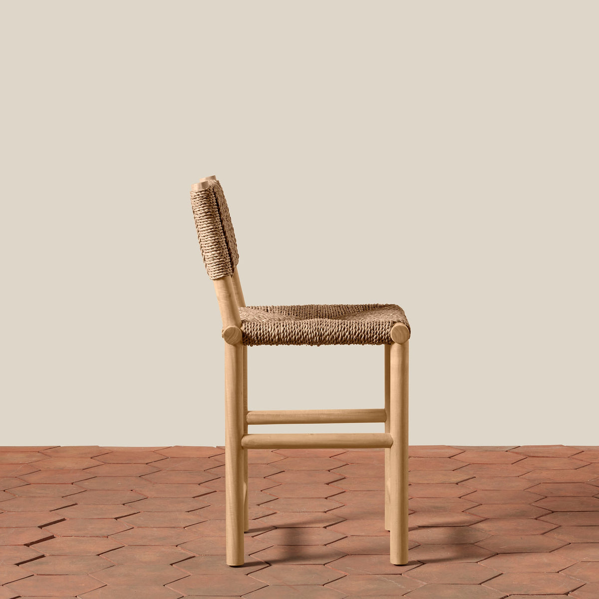 Side view of Hacienda Counter Stool showcasing woven seagrass seat and beechwood frame on terracotta tile floor