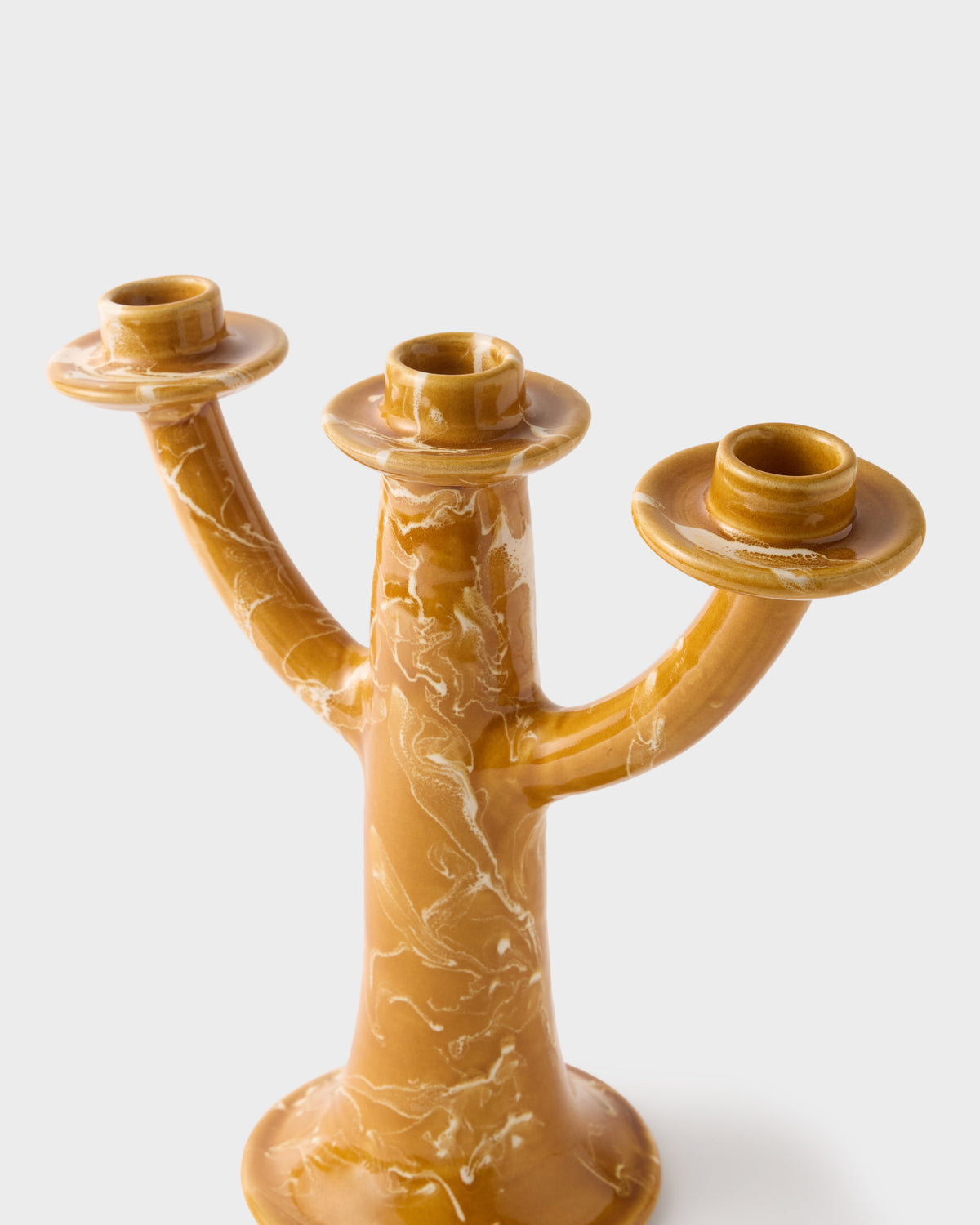 Close-up of Marbled Candelabra in Terracotta showcasing its sculptural three-arm form and warm marbled finish against a light background