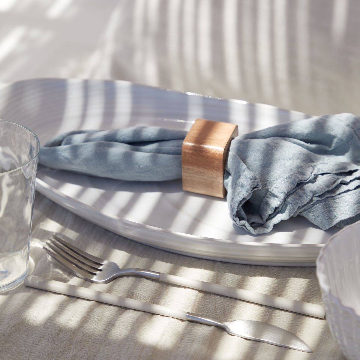 Close-up view of Maria Collection mint napkin showcasing washed linen texture with a table setting background