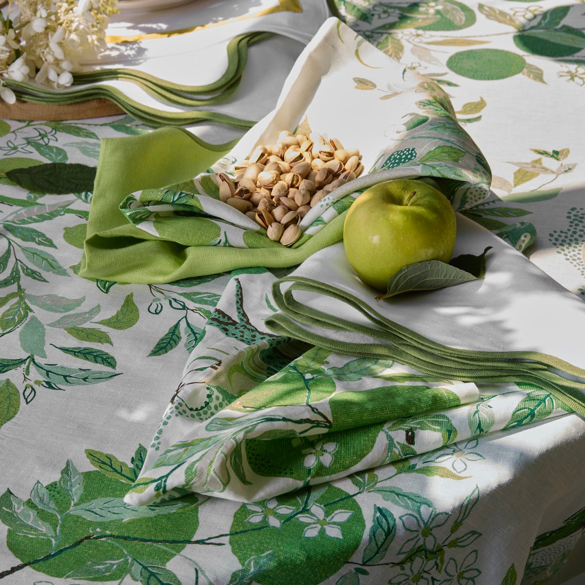 Close-up of Citrus Garden placemat in Grass showing green citrus botanical print and linen texture on a tabletop
