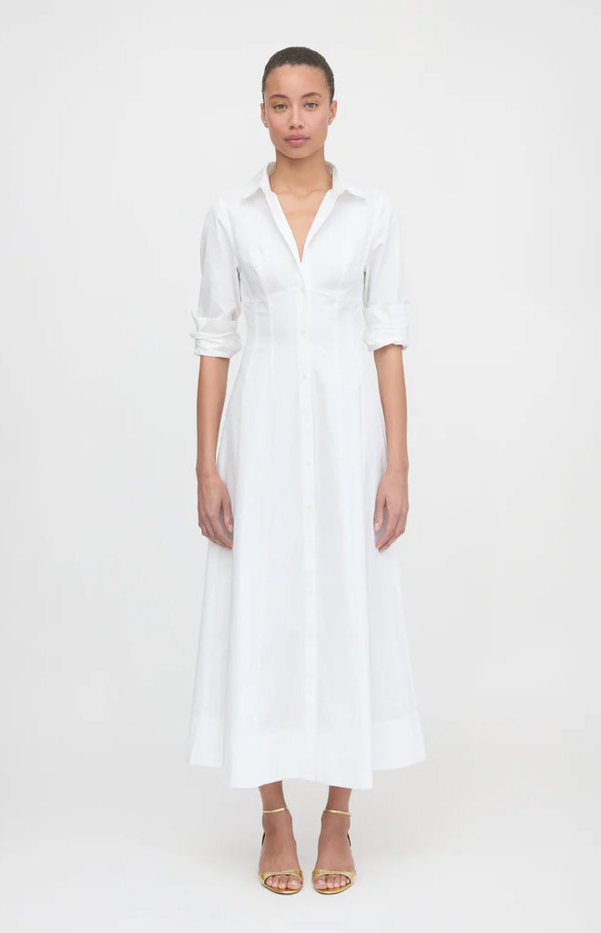 Front view of The Alandra Dress in white showcasing a structured tailored bodice, defined waist, full-length button-front skirt, pointed collar and rolled sleeves on a plain light background