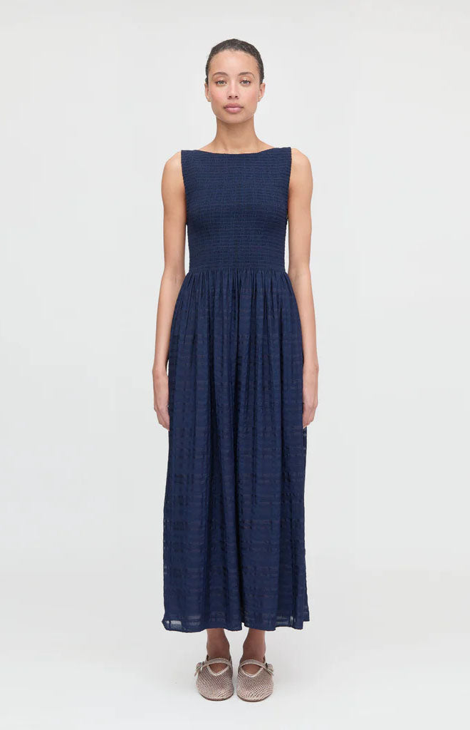 Front view of Cosima Nap Dress in navy sheer plaid showing smocked bodice and high boat neckline on light gray background