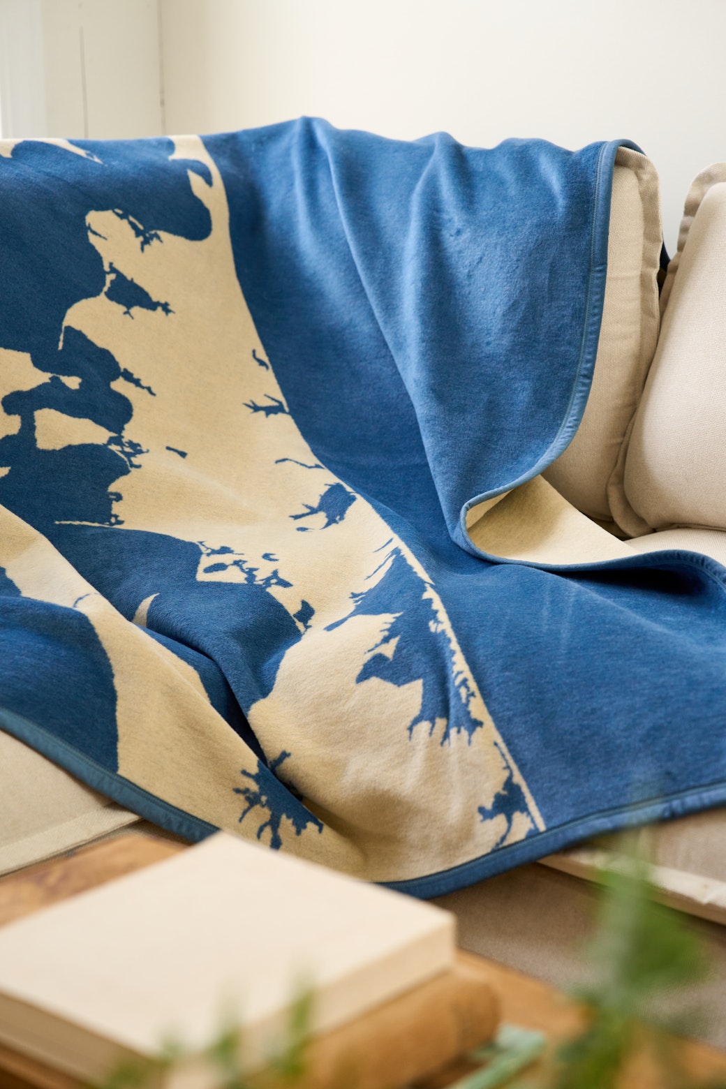 Blue and cream blanket with geographic map pattern draped over a chair.