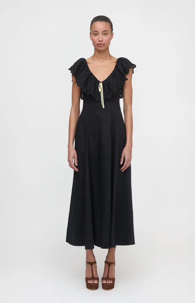 Front view of The Milani Dress in black with eyelet ruffle neckline and yellow bow, fitted bodice and flared midi skirt