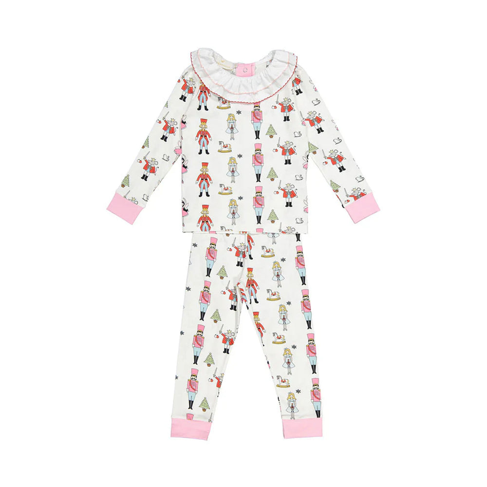 Flat lay of girl’s Nutcracker pajama set showing all-over nutcracker print, ruffled collar and pink cuffs on white background