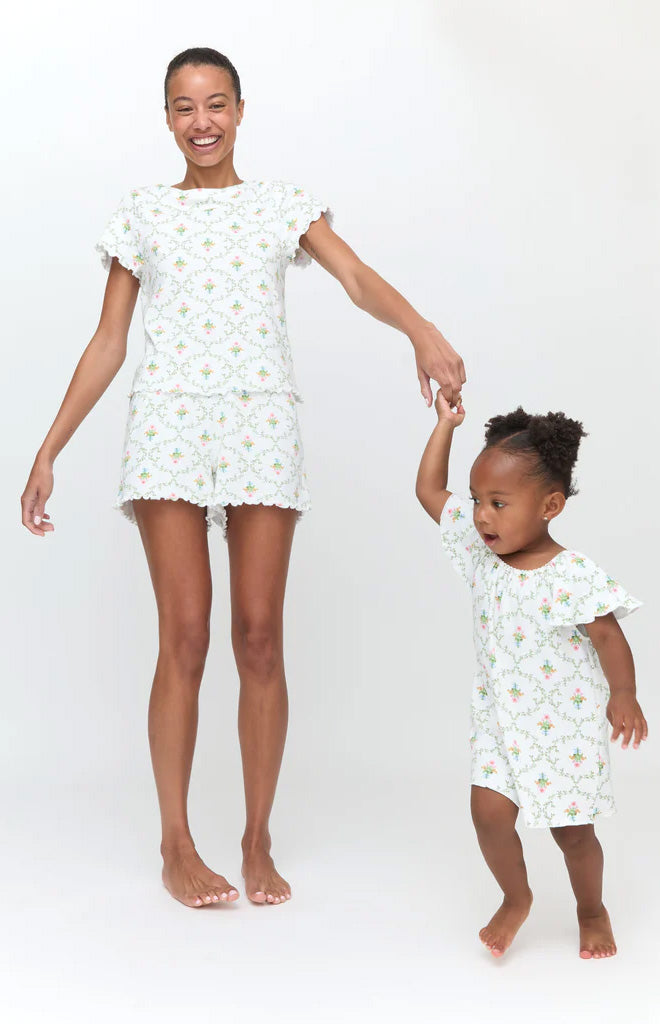 Front view of The Tiny Keira Dress in Pastel Trellis on a toddler showing smocked bodice and ruffled sleeves on white