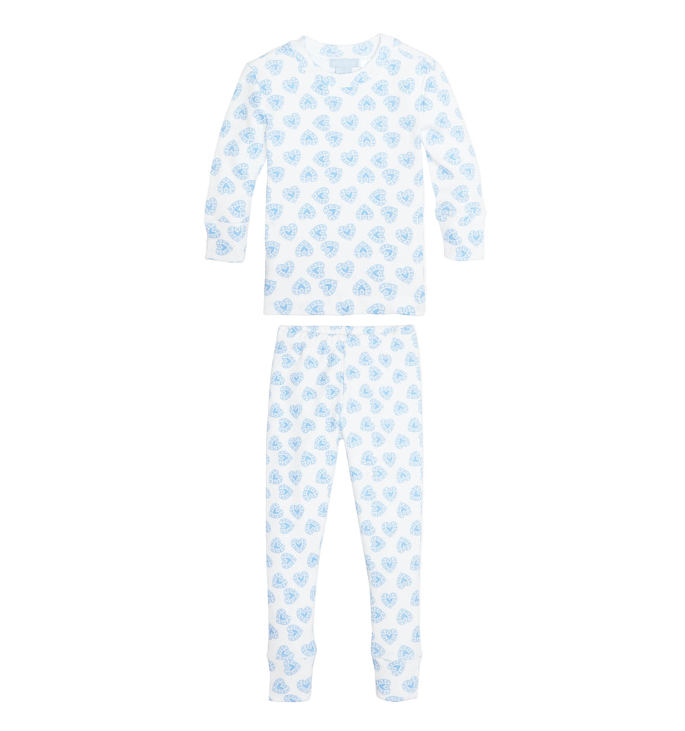 Flat-lay of Tiny Sully pajama set showing long-sleeve top and cuffed pants with blue doily-heart all-over print on white