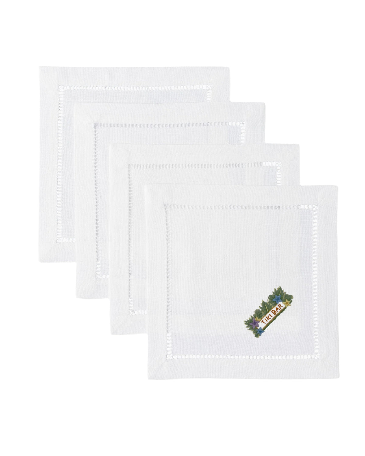 Front view of four white Tiki Bar cocktail napkins stacked, showing hand-embroidered ‘TIKI BAR’ floral motif and hemstitched border