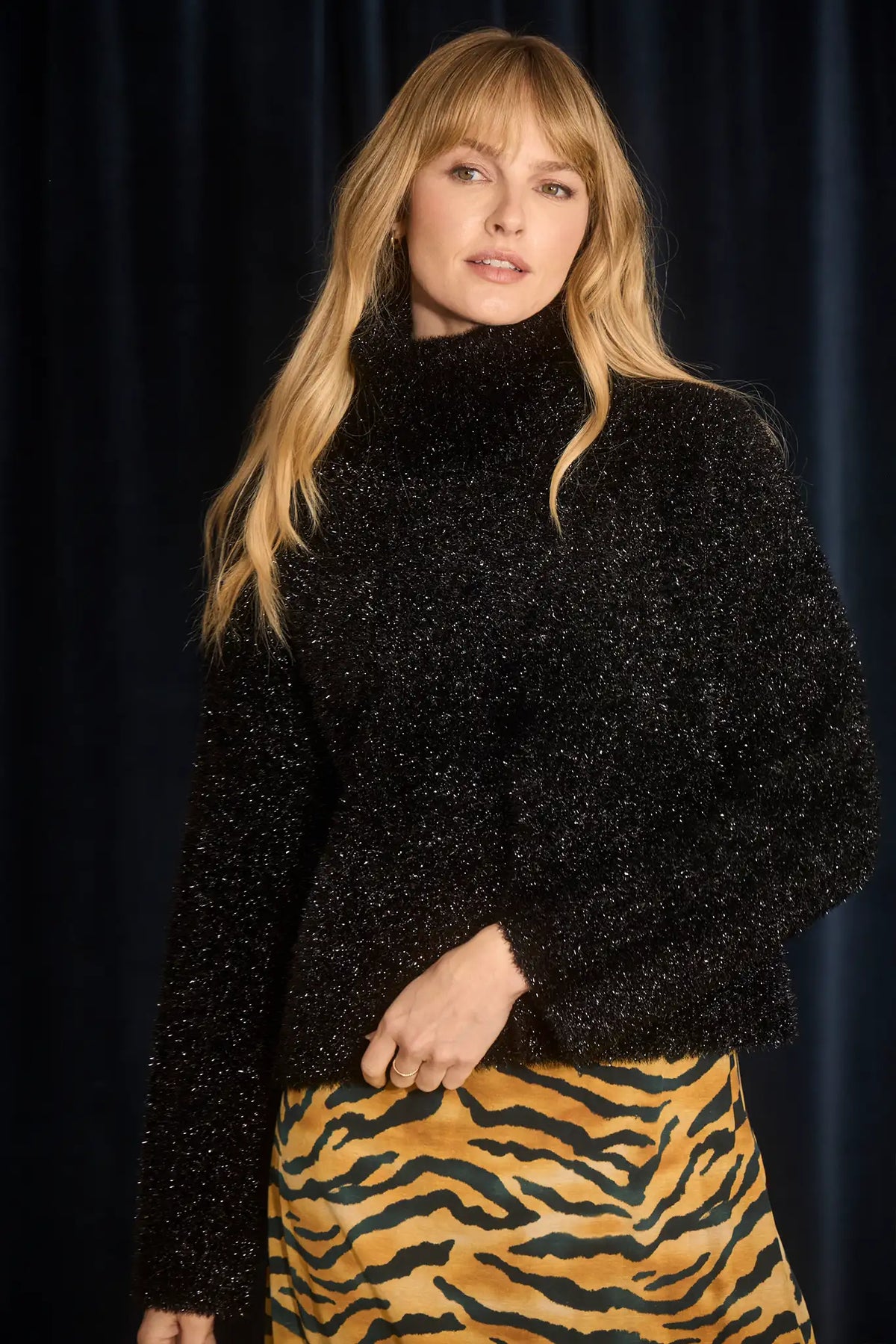 The turtleneck is made with shimmering yarn, oversized, long sleeves, and slightly cropped fit.