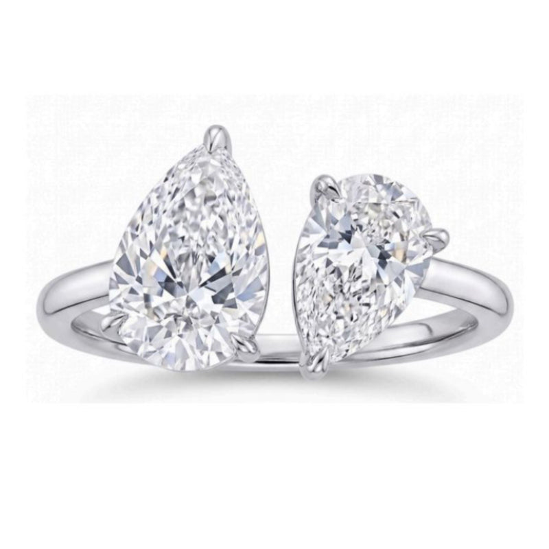 The Toi et Moi Pear Diamond Ring in White Gold showcases two G color pear-shaped diamonds set side by side in an open band, each secured by three prongs for a modern, elegant look.