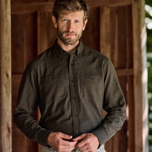 Man wearing a Tom Beckbe Dixon Brushed Cotton Twill Shirt stands before a wooden wall, looking at the camera.