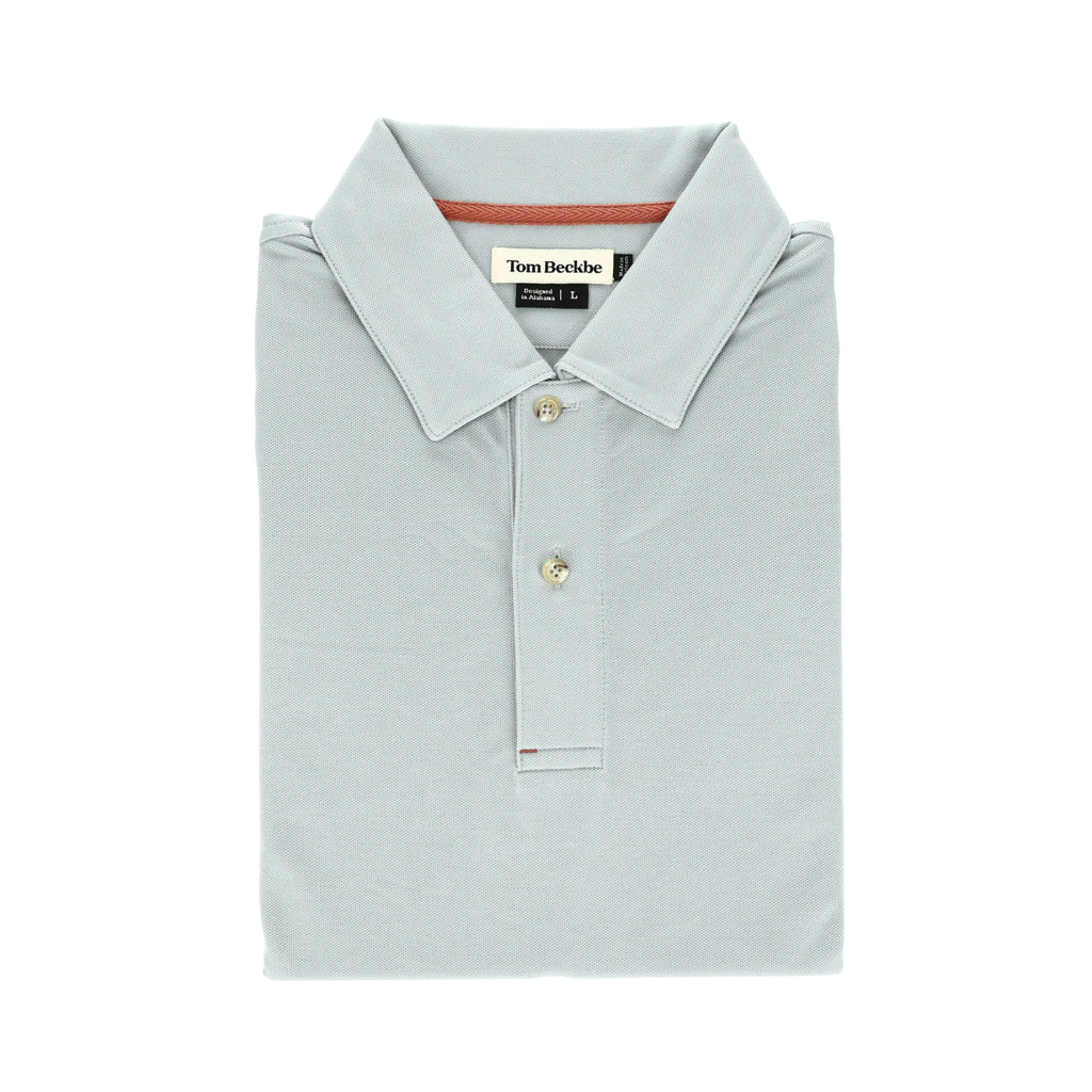 Folded Tom Beckbe Coastal Polo shirt in light gray with a collar, three buttons, and neck label.