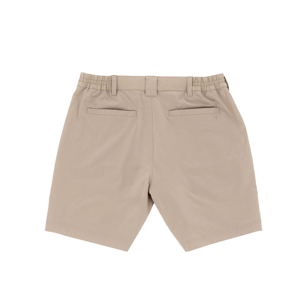 Tom Beckbes Crenshaw Performance Shorts are beige, with four-way stretch, belt loops, and two back pockets on white.