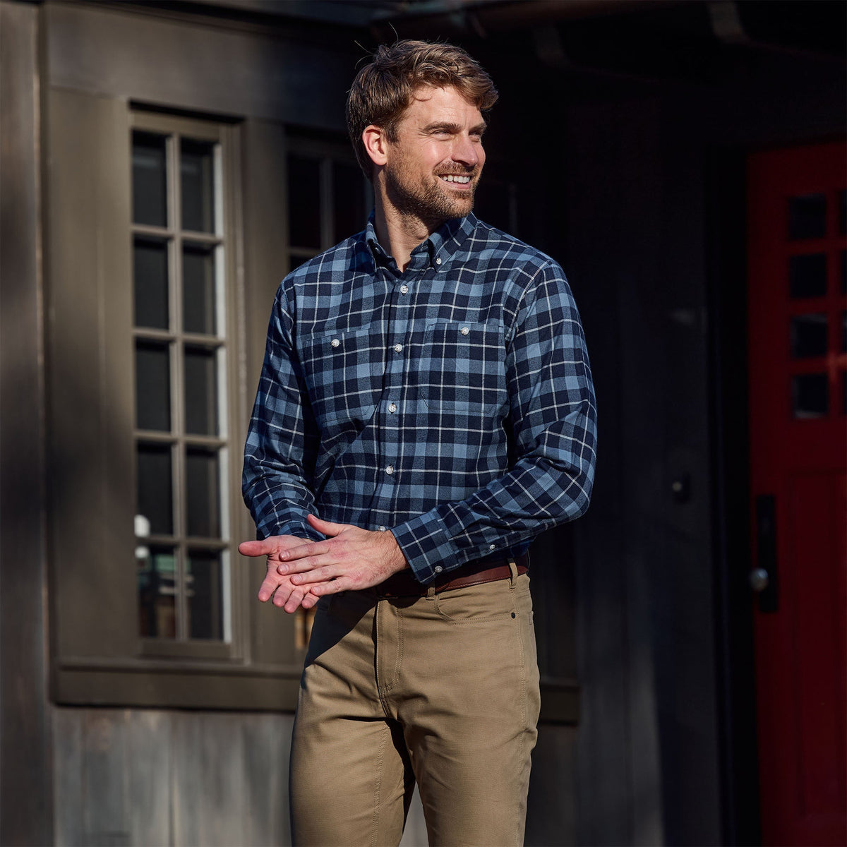 Man wearing a Tom Beckbe Dixon Brushed Cotton Twill Shirt and khaki pants, smiling outside in front of a building.