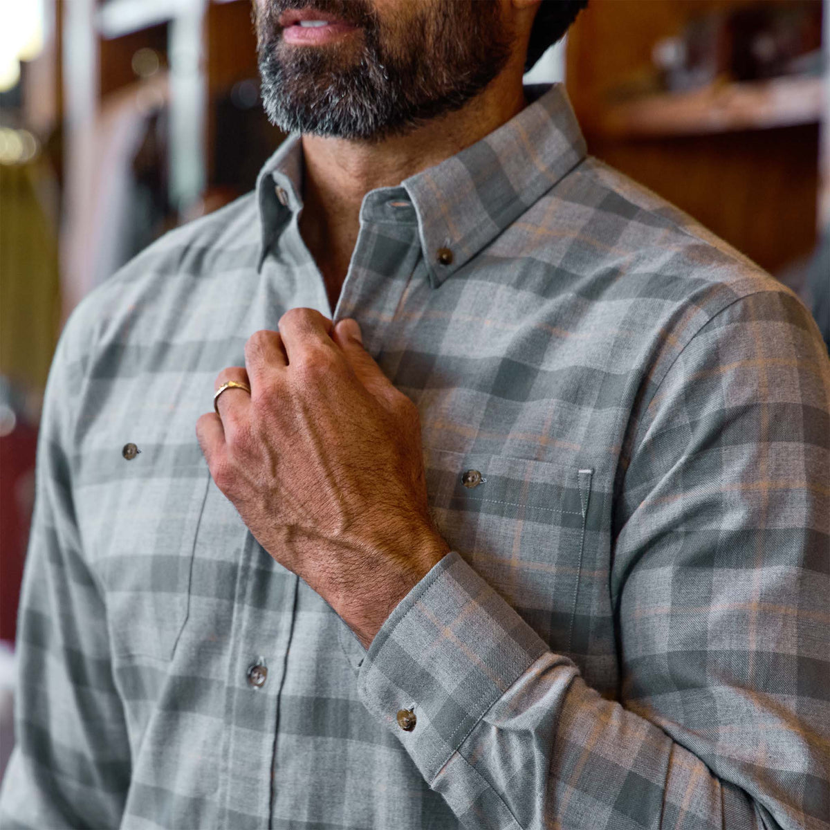 Man wearing the Tom Beckbe Dixon Brushed Cotton Twill Shirt touches front, displaying a gold ring on his finger.
