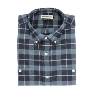 The Dixon Brushed Cotton Twill Shirt by Tom Beckbe features blue and gray plaid, white buttons, and a visible brand label.