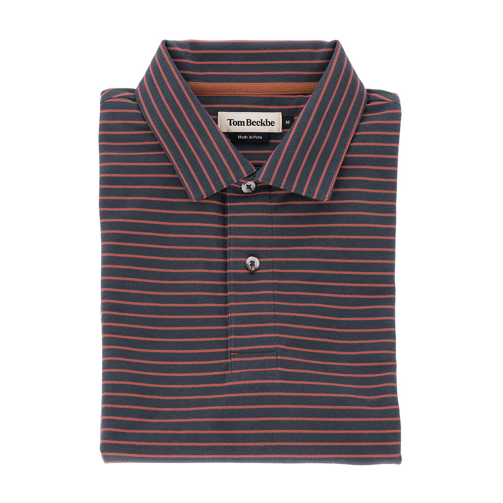 A folded Tom Beckbe Hutton Performance Polo for men in navy with thin red stripes and a two-button collar.