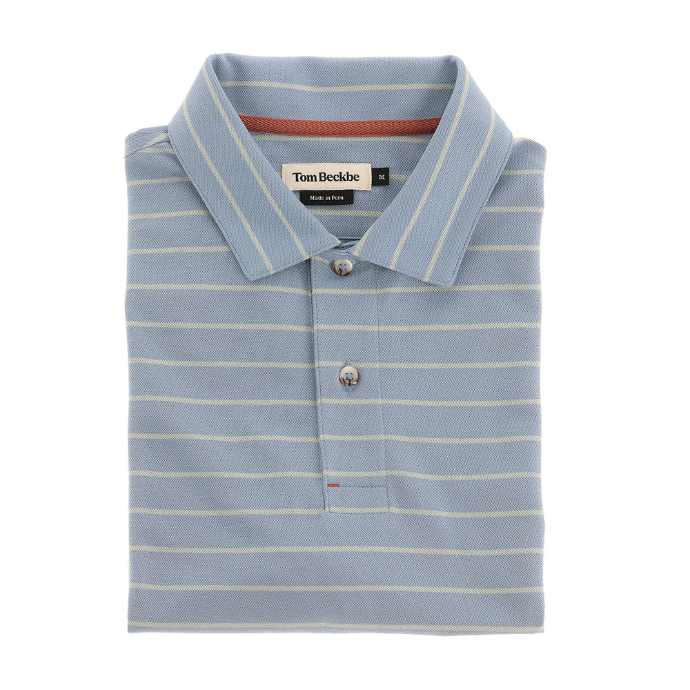 A folded light blue Hutton Performance Polo by Tom Beckbe with thin white stripes and a branded collar label.