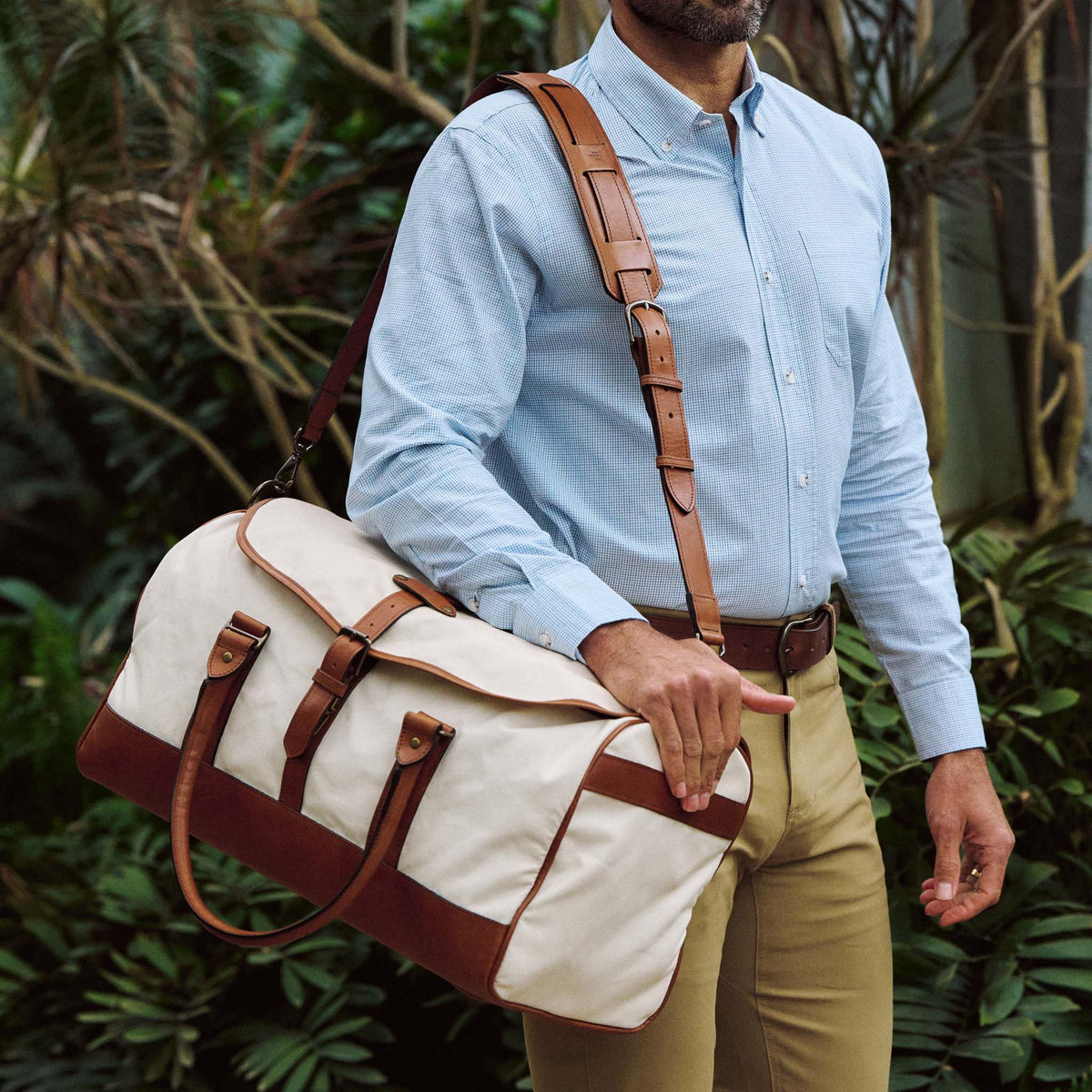A man carries the Tom Beckbe Perdido Canvas Weekender Duffel Bag over his shoulder.