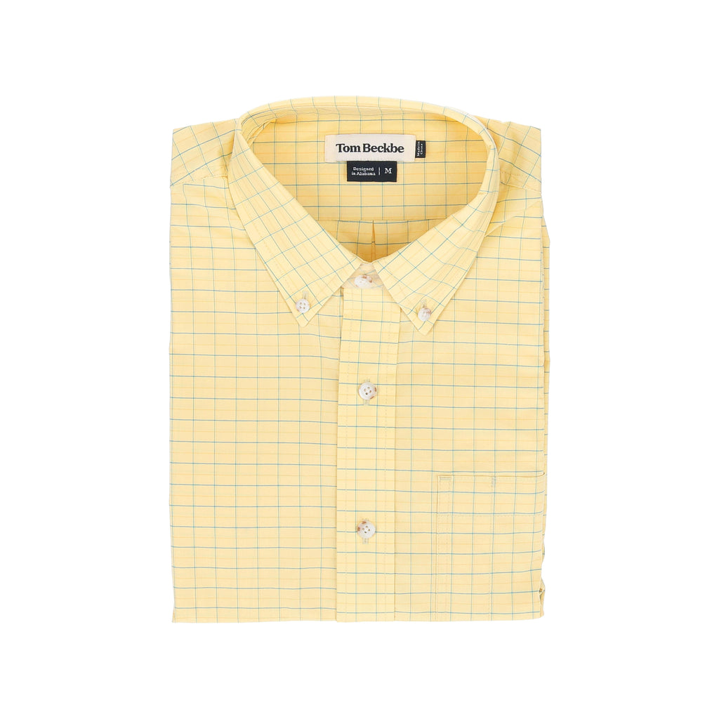 A folded yellow checkered lightweight Powell Performance Shirt with a Tom Beckbe label.