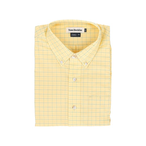 A folded yellow checkered lightweight Powell Performance Shirt with a Tom Beckbe label.