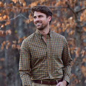 A man smiles outdoors before autumn trees, wearing the Tom Beckbe Powell Performance Shirt.