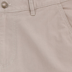 Close-up of Tom Beckbe Reid Short, light beige, mid-rise with button, belt loop, seam details, and antique brass zip fly.