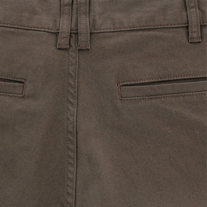 Close-up of Tom Beckbes Reid Short in mid-rise brown with waistband, belt loops, brass zip fly, and two closed welt pockets.