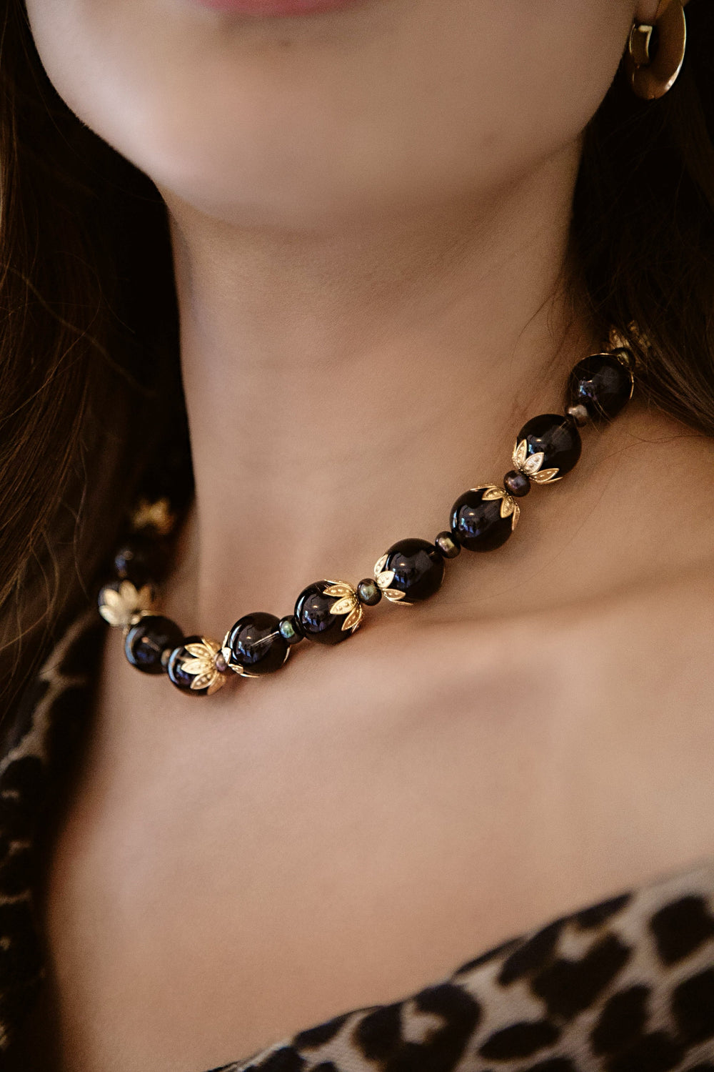 Front close-up of Tommie Necklace showing smoky quartz beads, pearls, and gold floral bead caps on a model’s neck