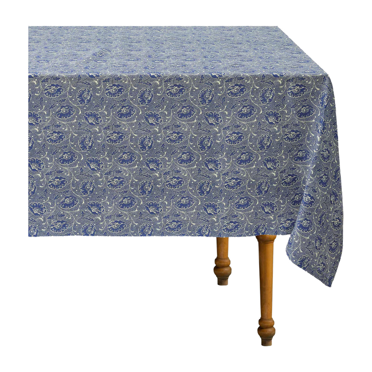 Angled view of Toscana Blue Tablecloth showcasing blue and white floral vine motif on a wooden table with white background