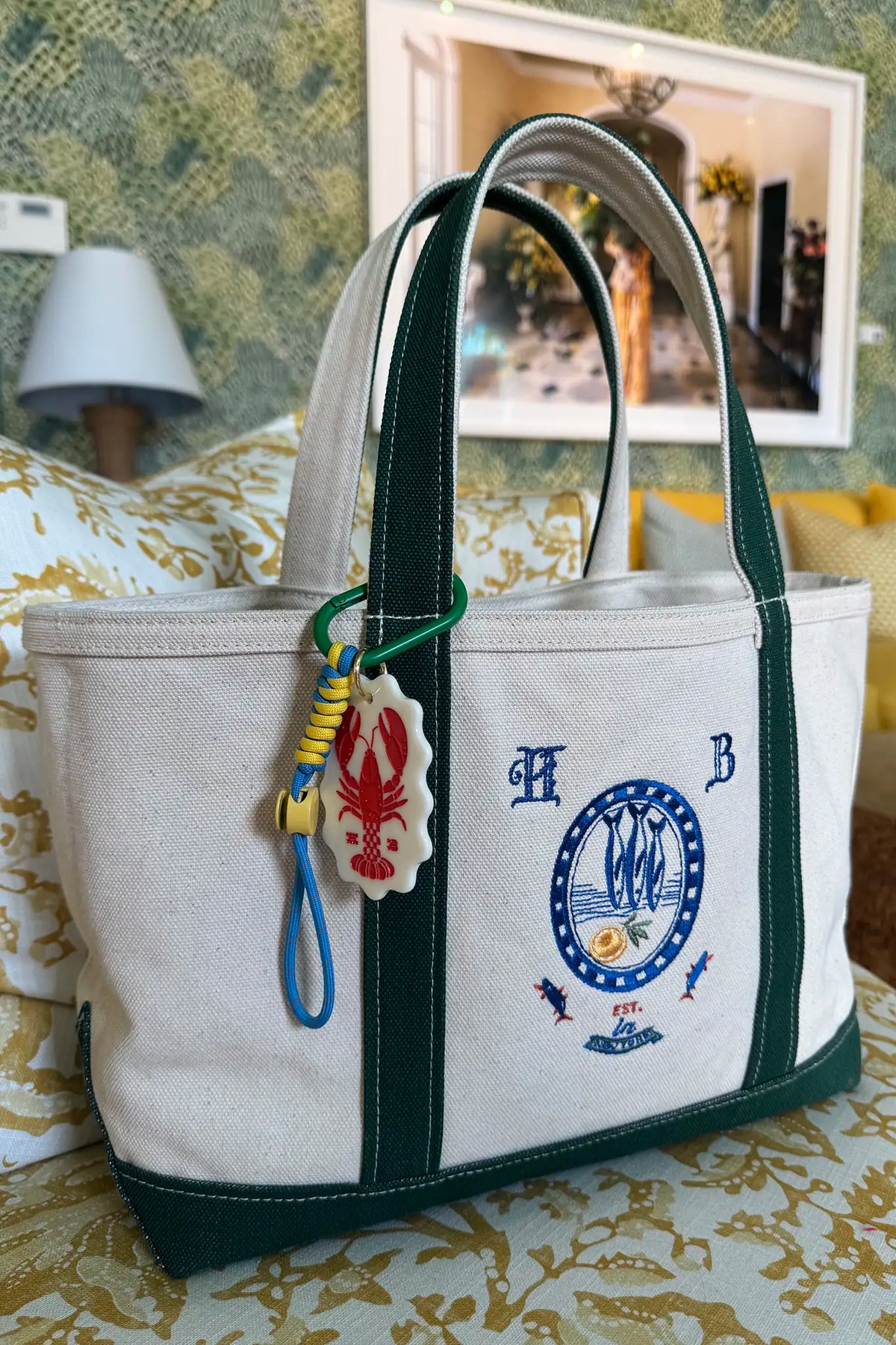 The medium canvas tote bag with green handles and fish motifs.