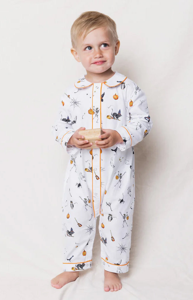 Front view of Trick or Treat Cambridge romper on toddler showcasing Halloween print and orange piped trim on white background