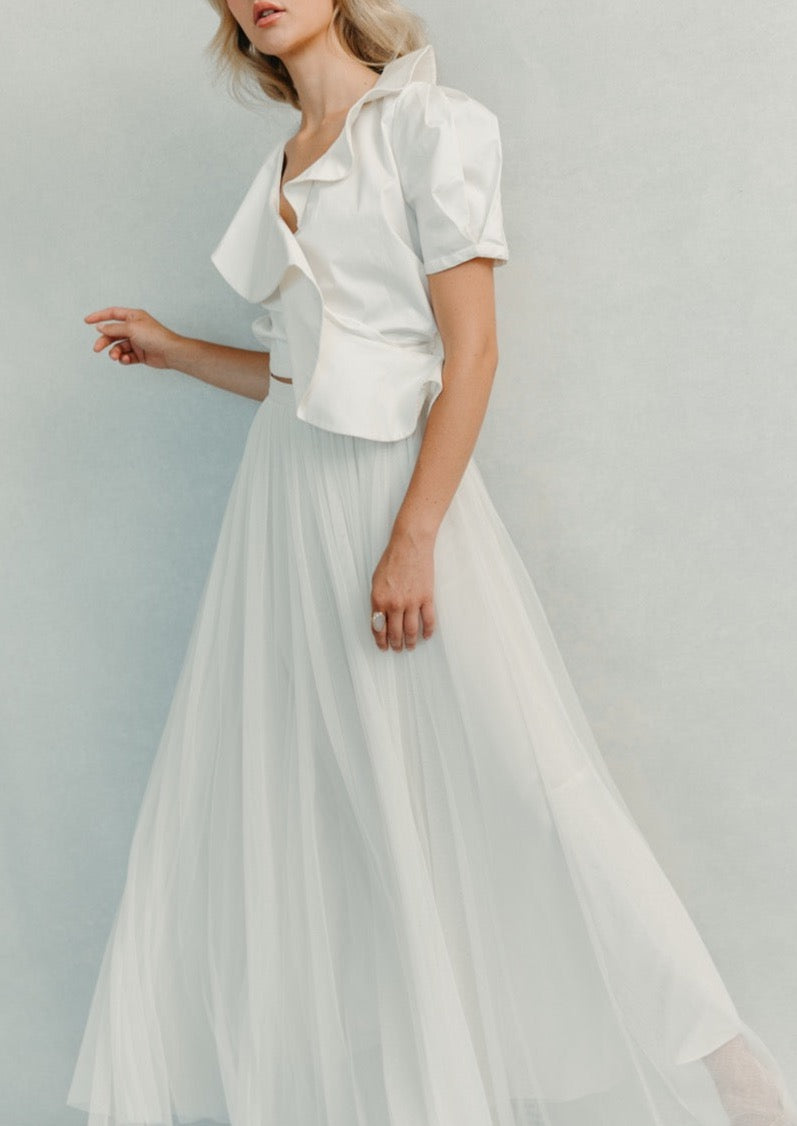 Three quarter view of Tuscany skirt showing ivory full length silk tulle layers and soft pleats on a light gray background
