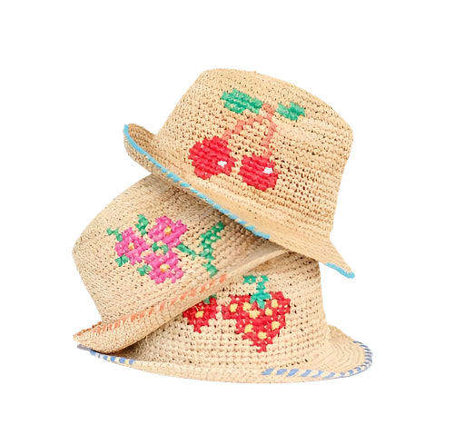 Stacked view of two Tutti Frutti straw crochet bucket hats showcasing embroidered cherries and flowers and blue-trimmed brims on white background