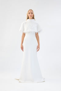 A model viewed from the front wearing a white textured faux fur bridal cape over a white gown.