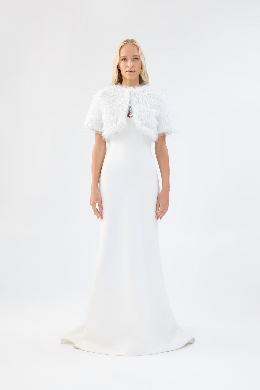 A model viewed from the front wearing a metallic white short-sleeve faux fur bridal bolero.