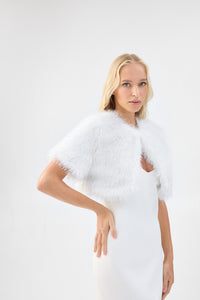 A model in three-quarter view wearing a metallic white short-sleeve faux fur bridal bolero.