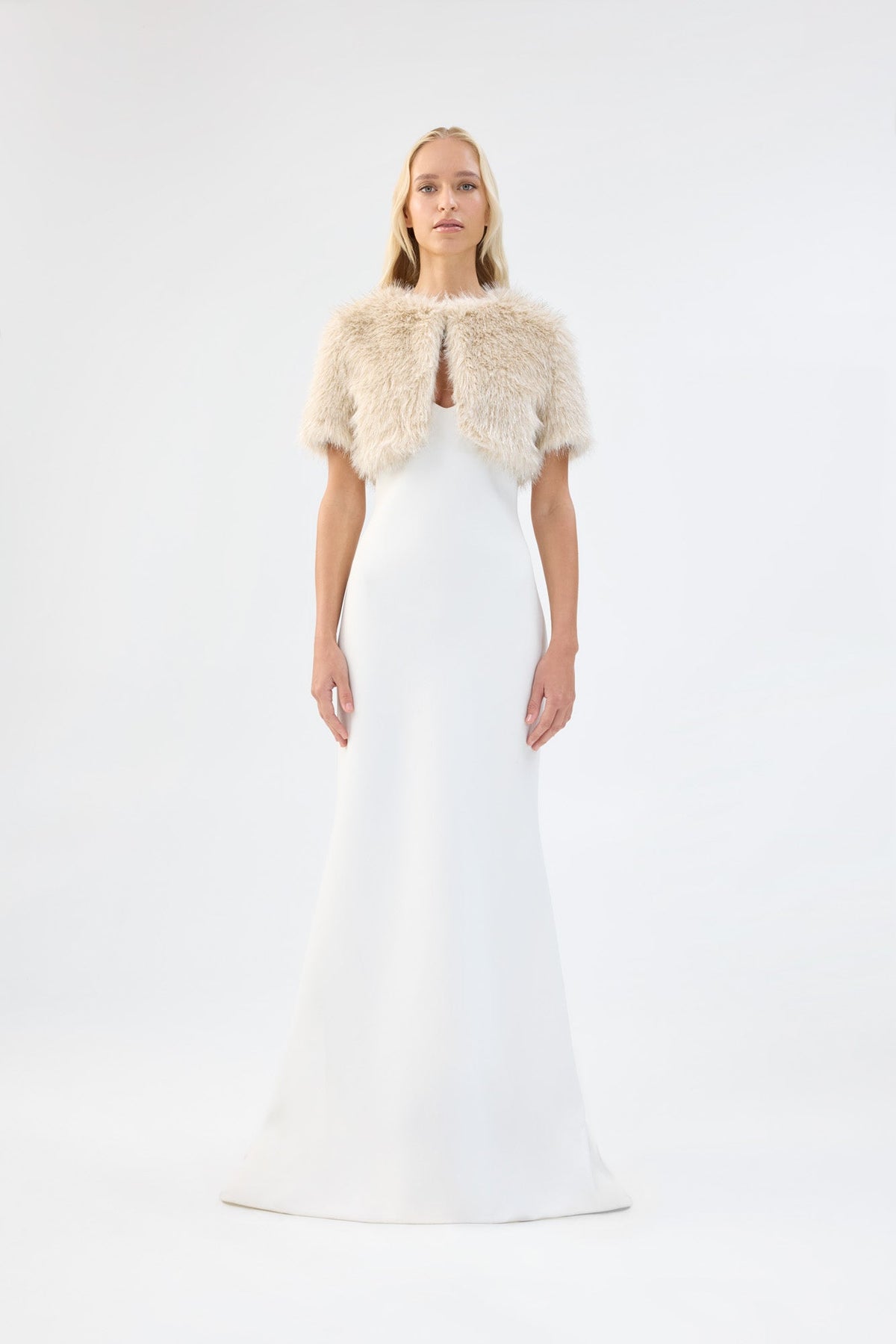A model viewed from the front wearing a metallic cream short-sleeve faux fur bridal bolero.
