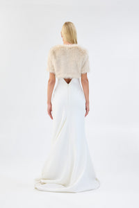 A model viewed from the back wearing a metallic cream short-sleeve faux fur bridal bolero.