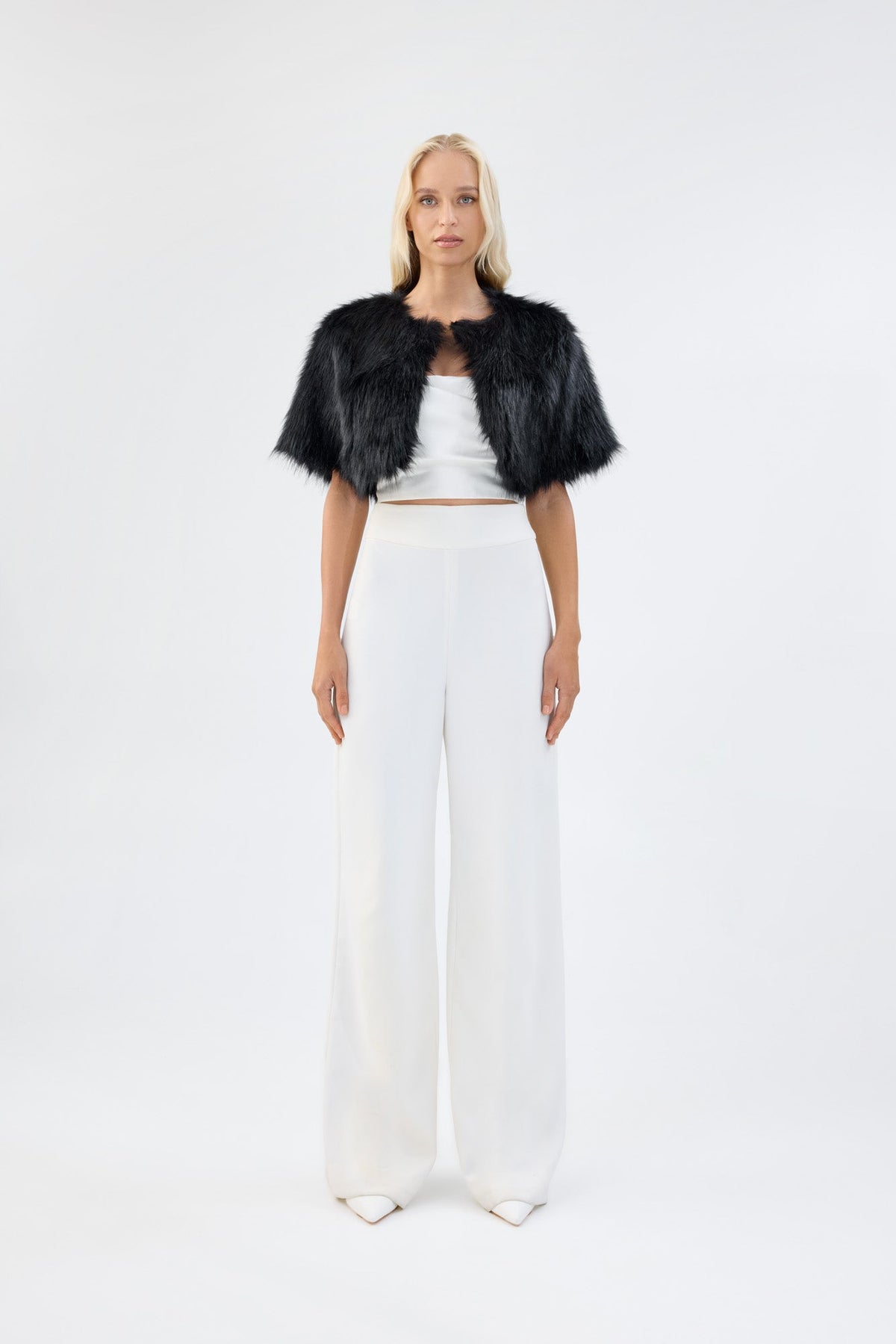A model viewed from the front wearing a black faux fur bridal bolero.