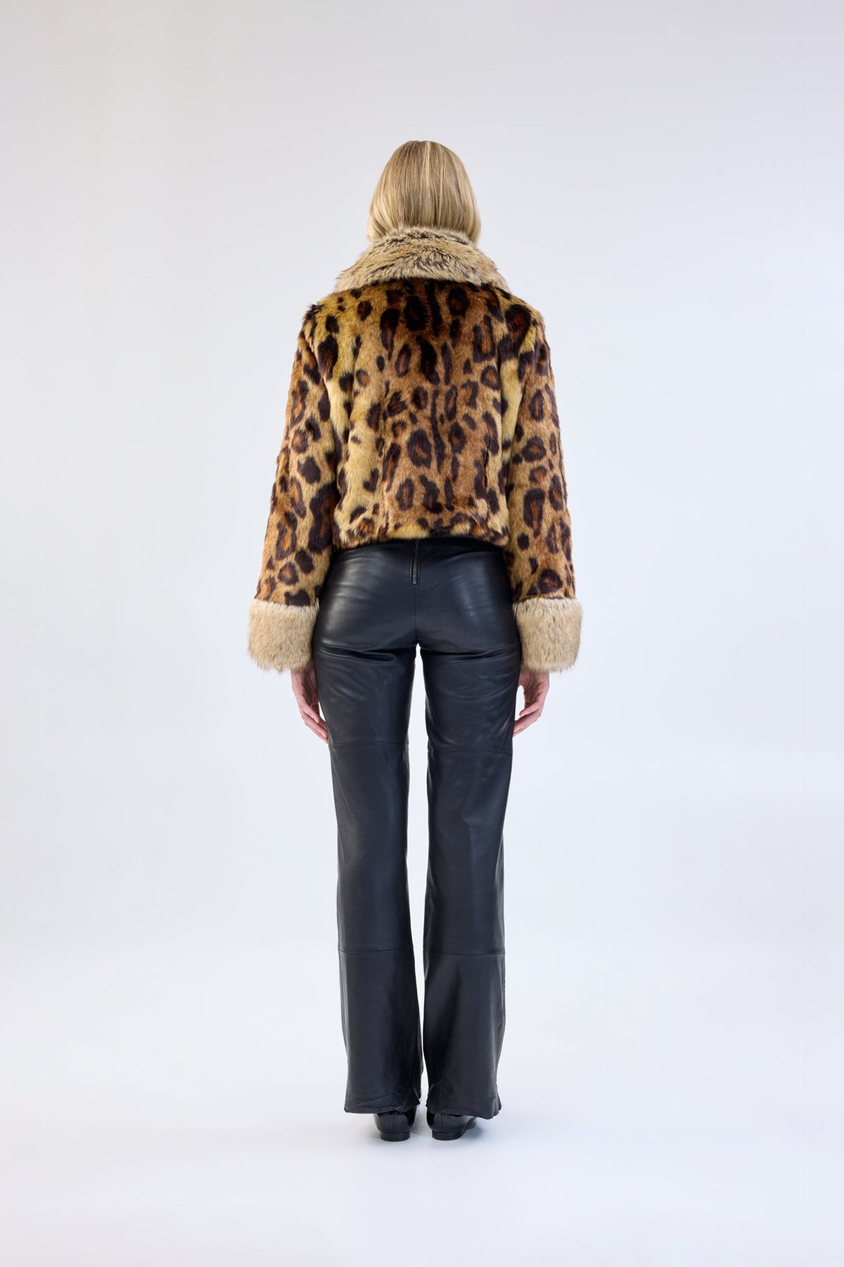 A model viewed from the back wearing a leopard print faux fur jacket.