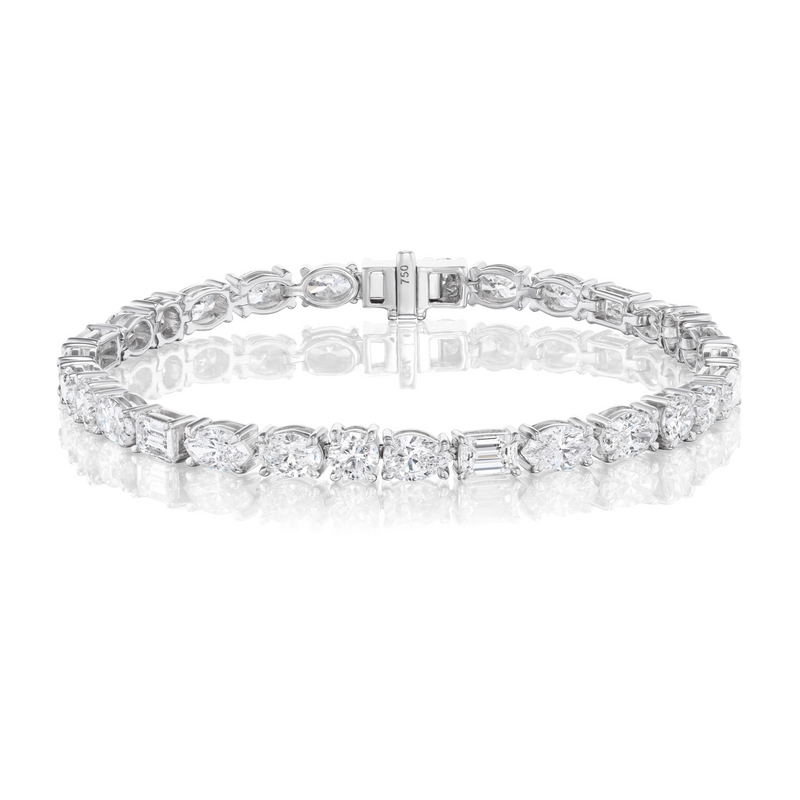 The Medium East-West Mixed Shape Diamond Tennis Bracelet in 18k white gold features alternating oval, marquise, emerald, and round diamonds, shown on a plain white background with a reflective surface.