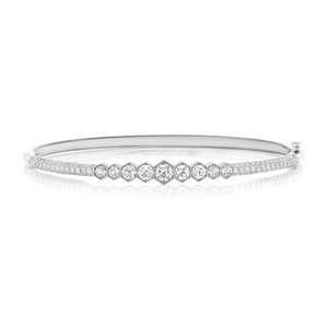 The Graduated Hexagon Bezel Set Diamond Pavé Bangle showcases SI clarity round and hexagonal center diamonds, framed by two slim rows of pavé-set diamonds along the silver band.