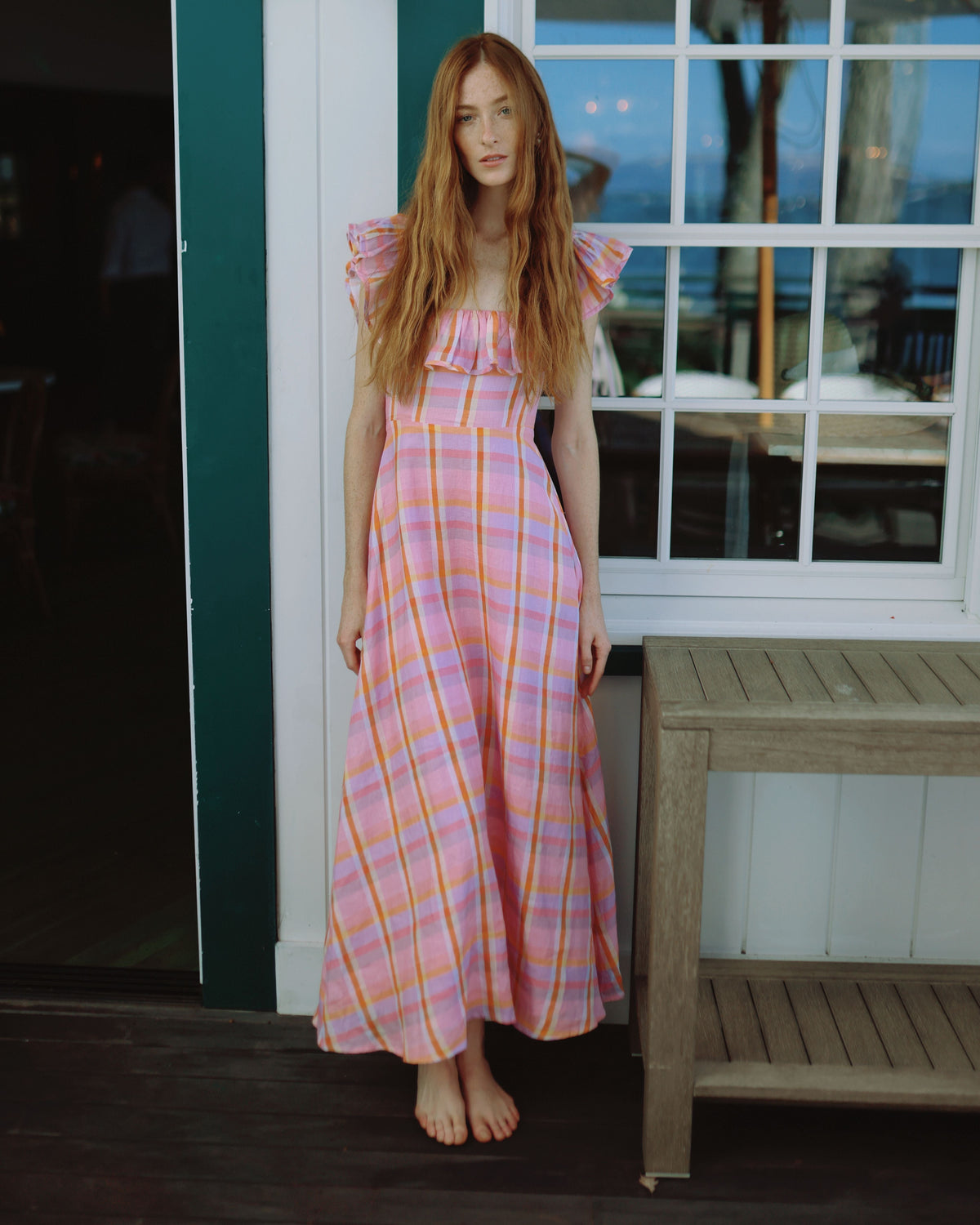 Front view of Parker Dress in Sherbet Plaid showing ruffle square neckline, fitted bodice, and ankle-length linen skirt on model by a window