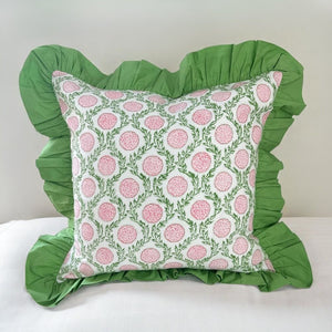 Decorative pillow with pink floral pattern and green ruffles on a white background