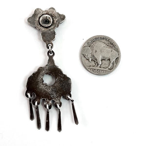 Close-up of vintage Zuni earrings showcasing dangling sterling silver and American turquoise with a coin for scale