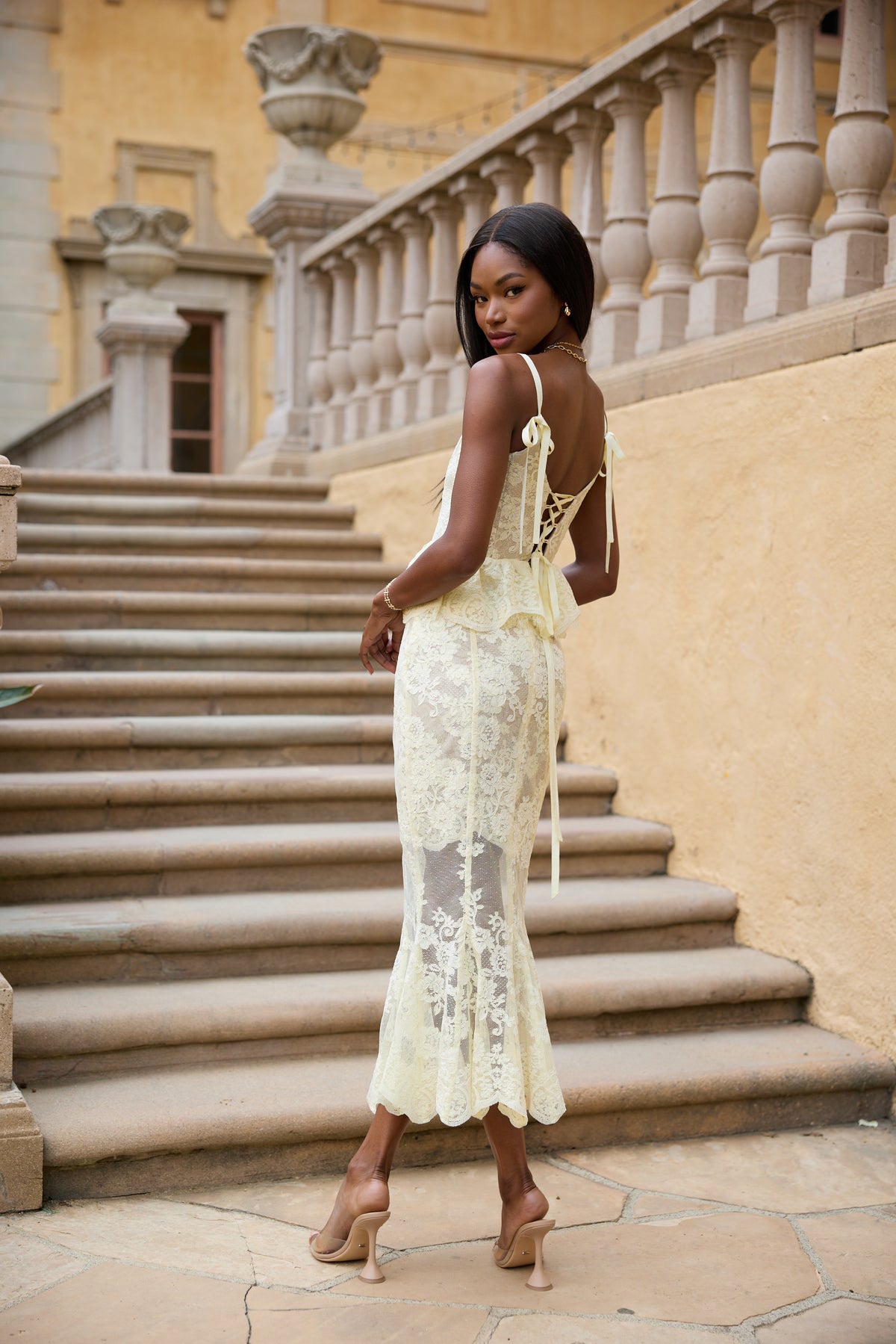 Back view of The Vinetta Set in Transparent Yellow Lace showcasing ribbon straps and embroidered lace with stone steps